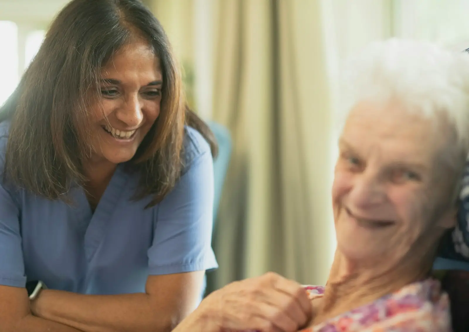 A nurse caring for a smiling resident
